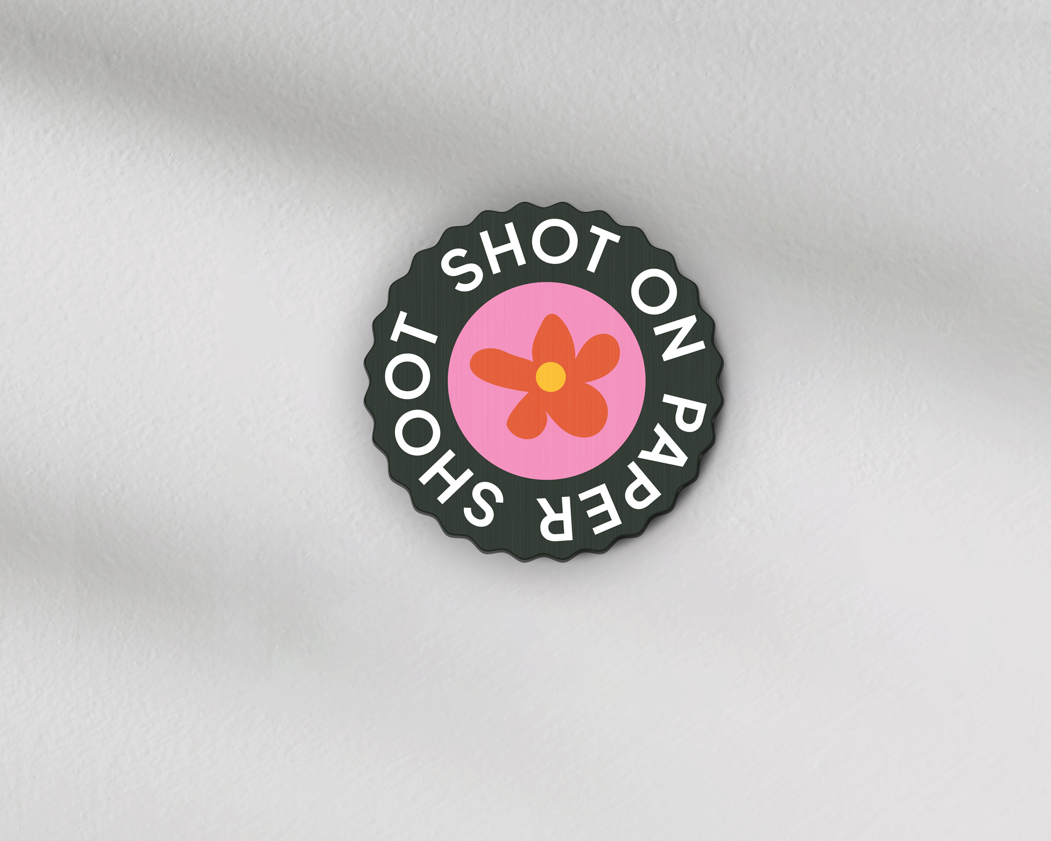Shot on paper shoot text lens cover with centre red and yellow flower graphic with grip groves 